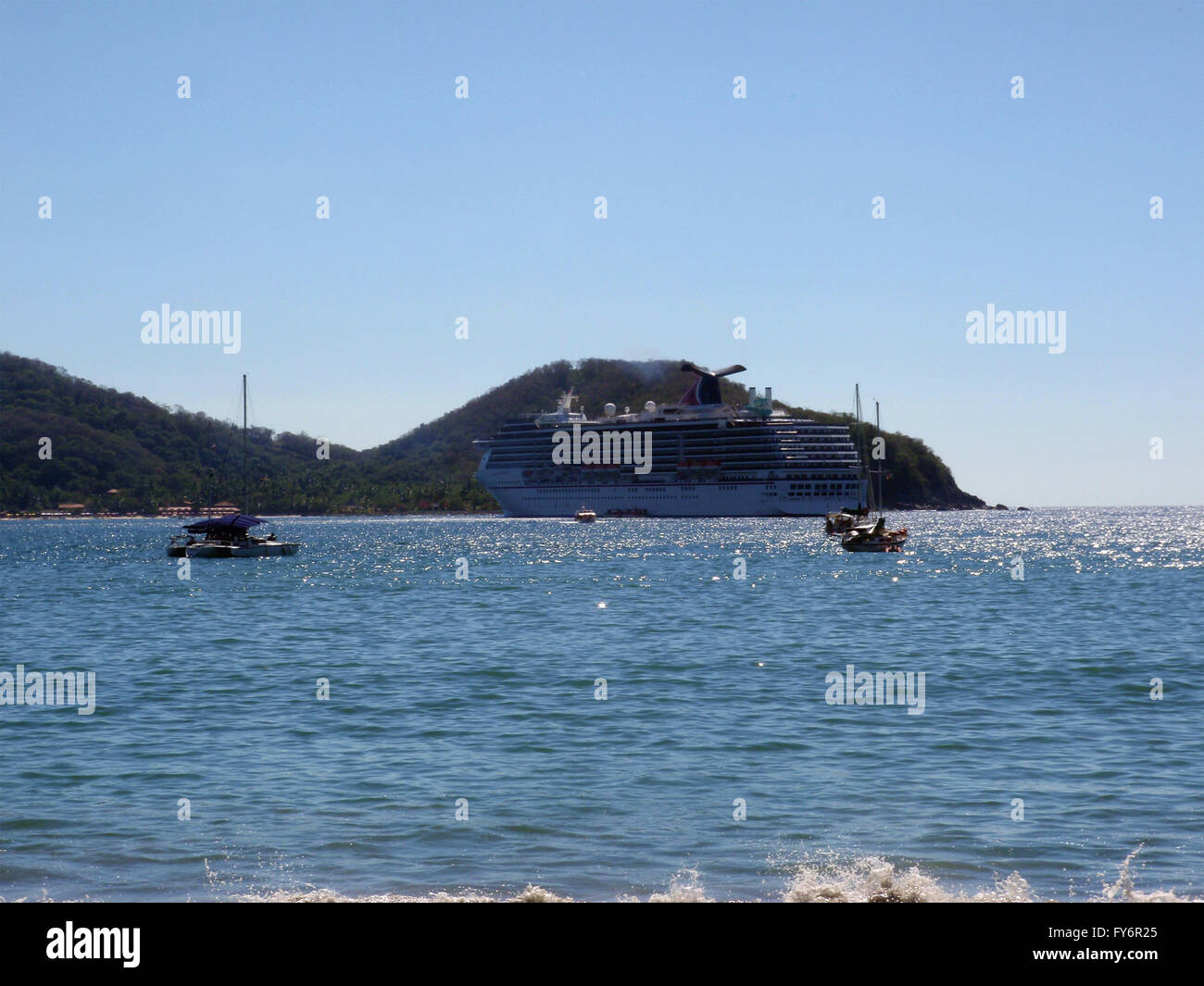 ZIHUATANEJO, MEXICO - JANUARY 10: Carnival Cruise ship rests in bay with small boats in forground during port of call stop in Zi Stock Photo