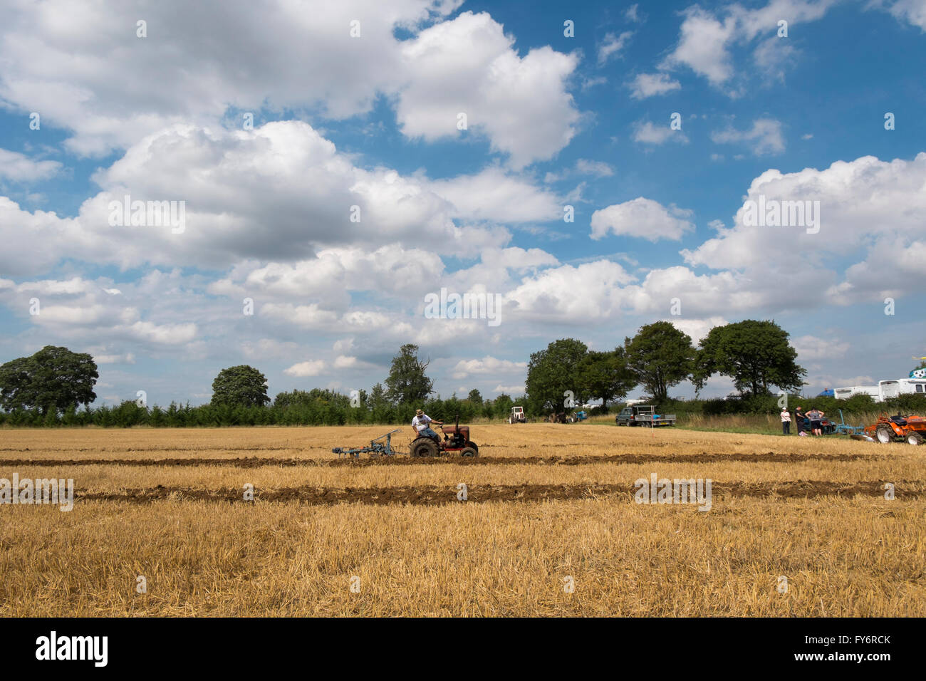 Man driving a small vintage tractor ploughing a field at the Fairford Steam Rally, Gloucestershire, UK Stock Photo