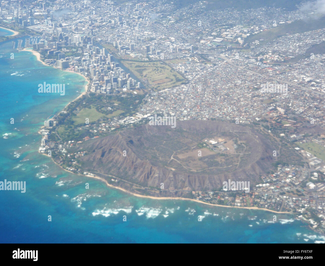 Aerial of Diamond Head Crater, Waikiki, and Honolulu with wave bracking