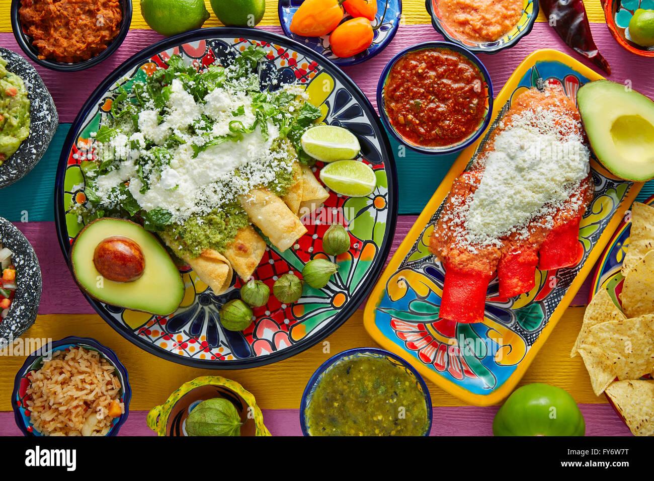 Green and red enchiladas with mexican sauces mix in colorful table Stock Photo
