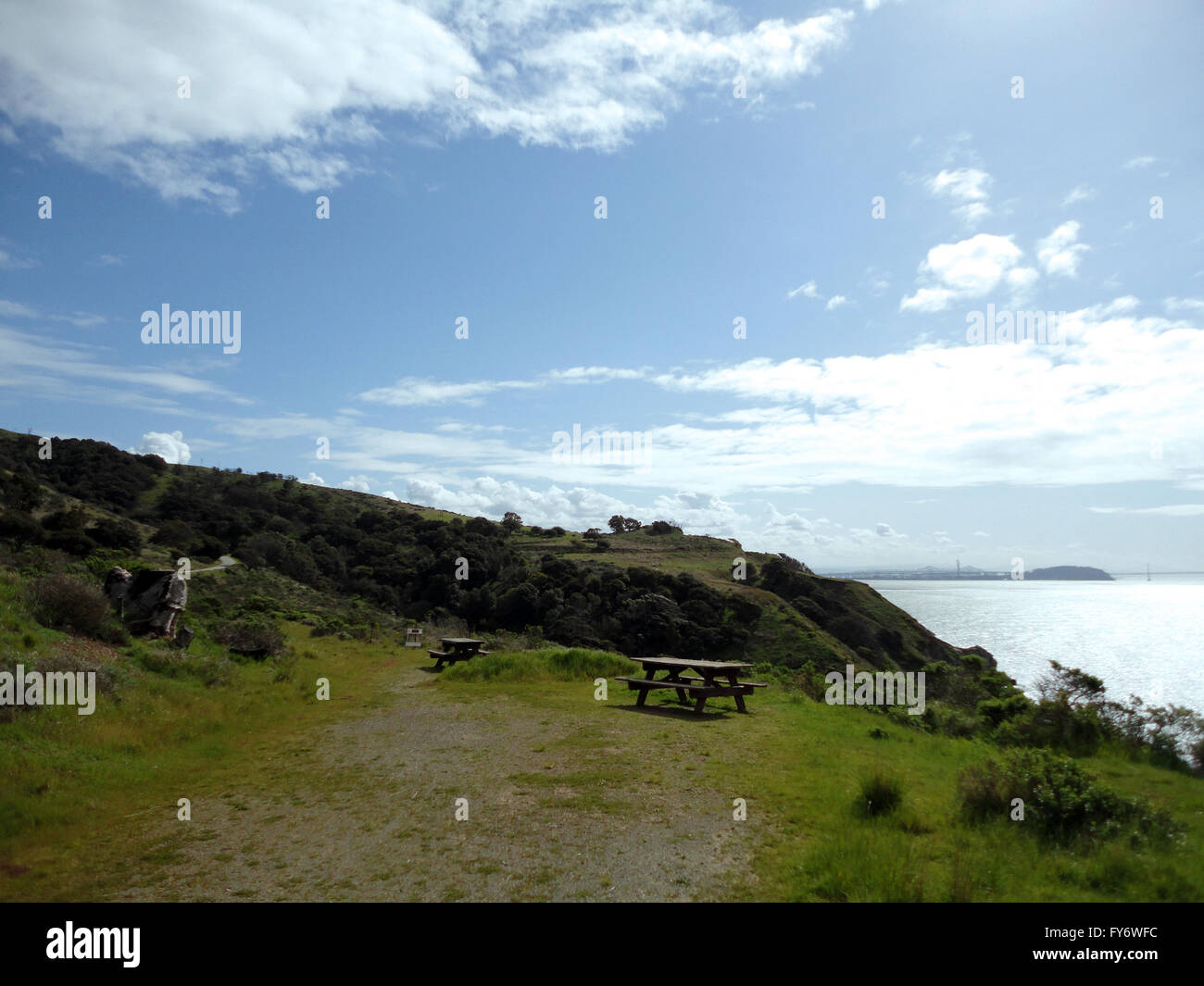 Picnic Tables on Angel Island with Bay Bridge in distance with dramatic