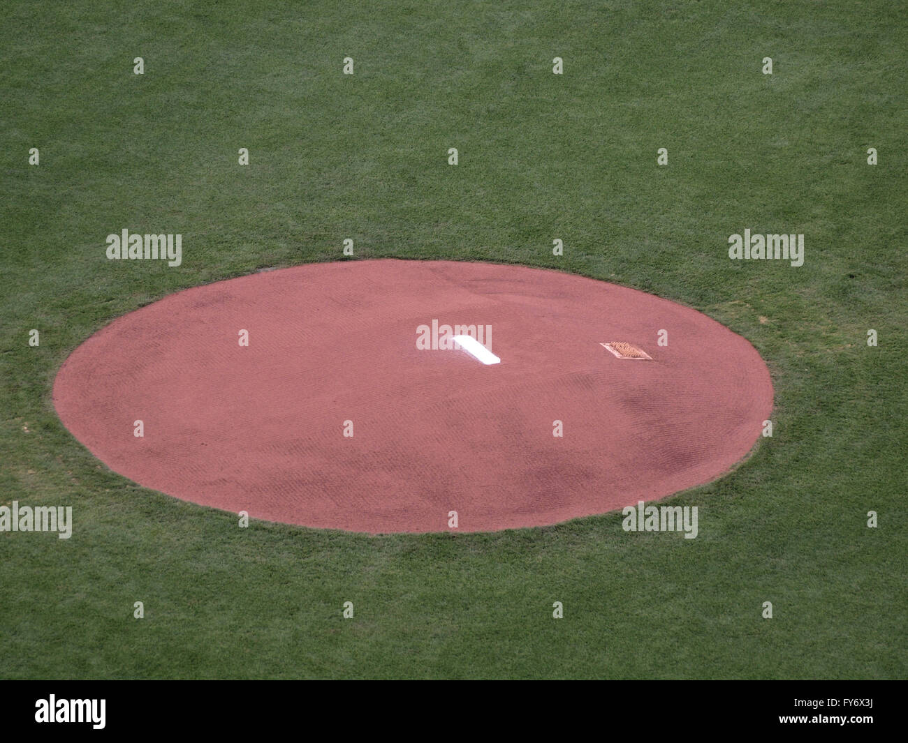 Baseball mound sits empty in pregame perfection before players begin destroying the surface with their clets. Stock Photo