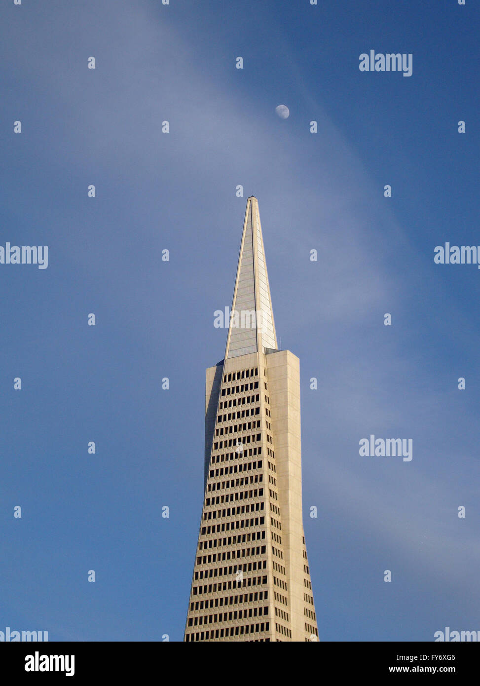 Transamerica Skyscaper in San Francisco with the moon hanging overhead during the early evening Stock Photo