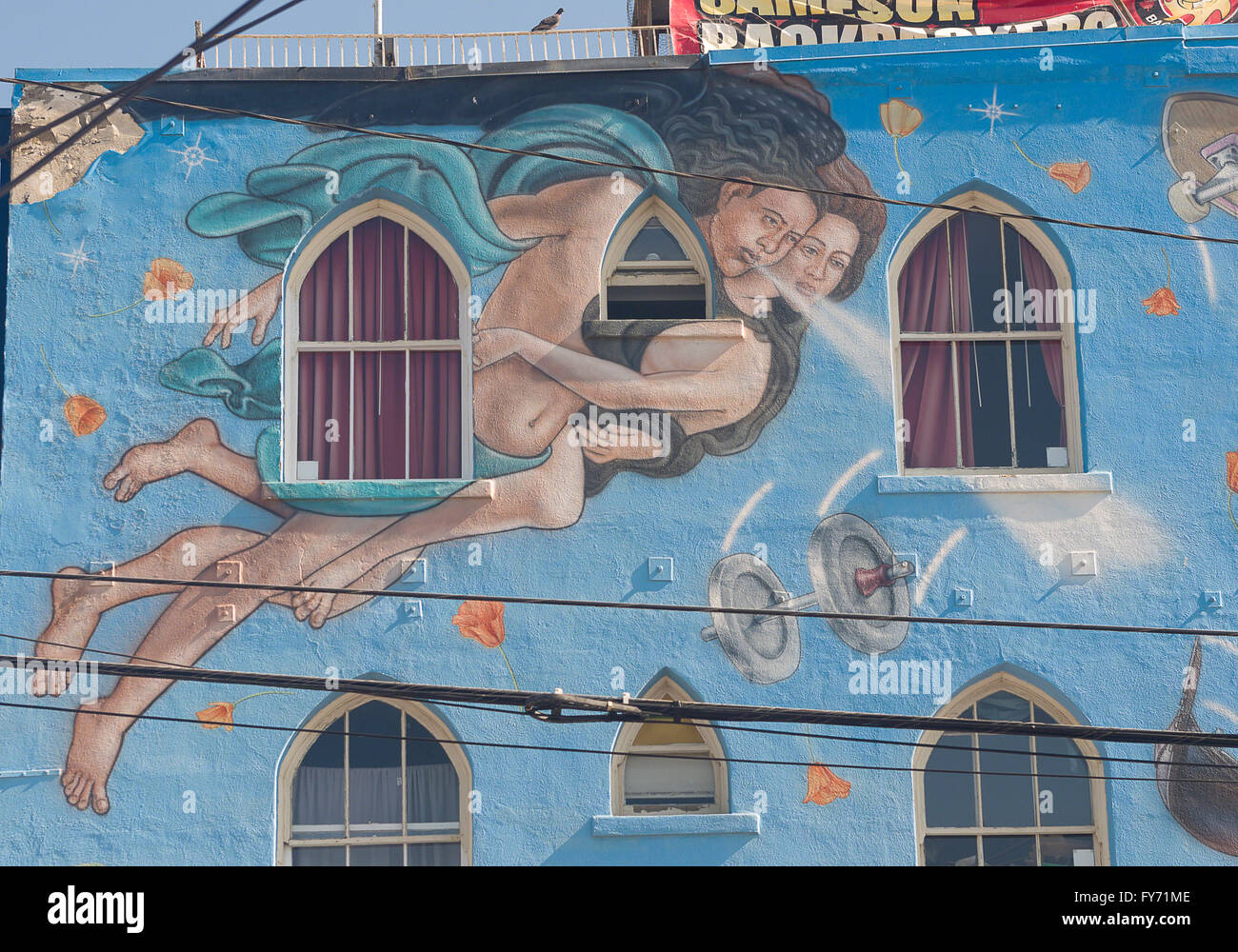 A portion of a colorful mural on the side of a building in Venice, California depicts a man with holding a woman while flying Stock Photo