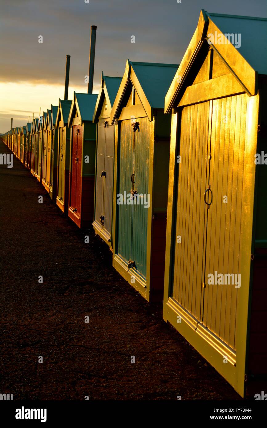 brightly colored doors of beach huts on Hove UK seafront at sunset Stock Photo