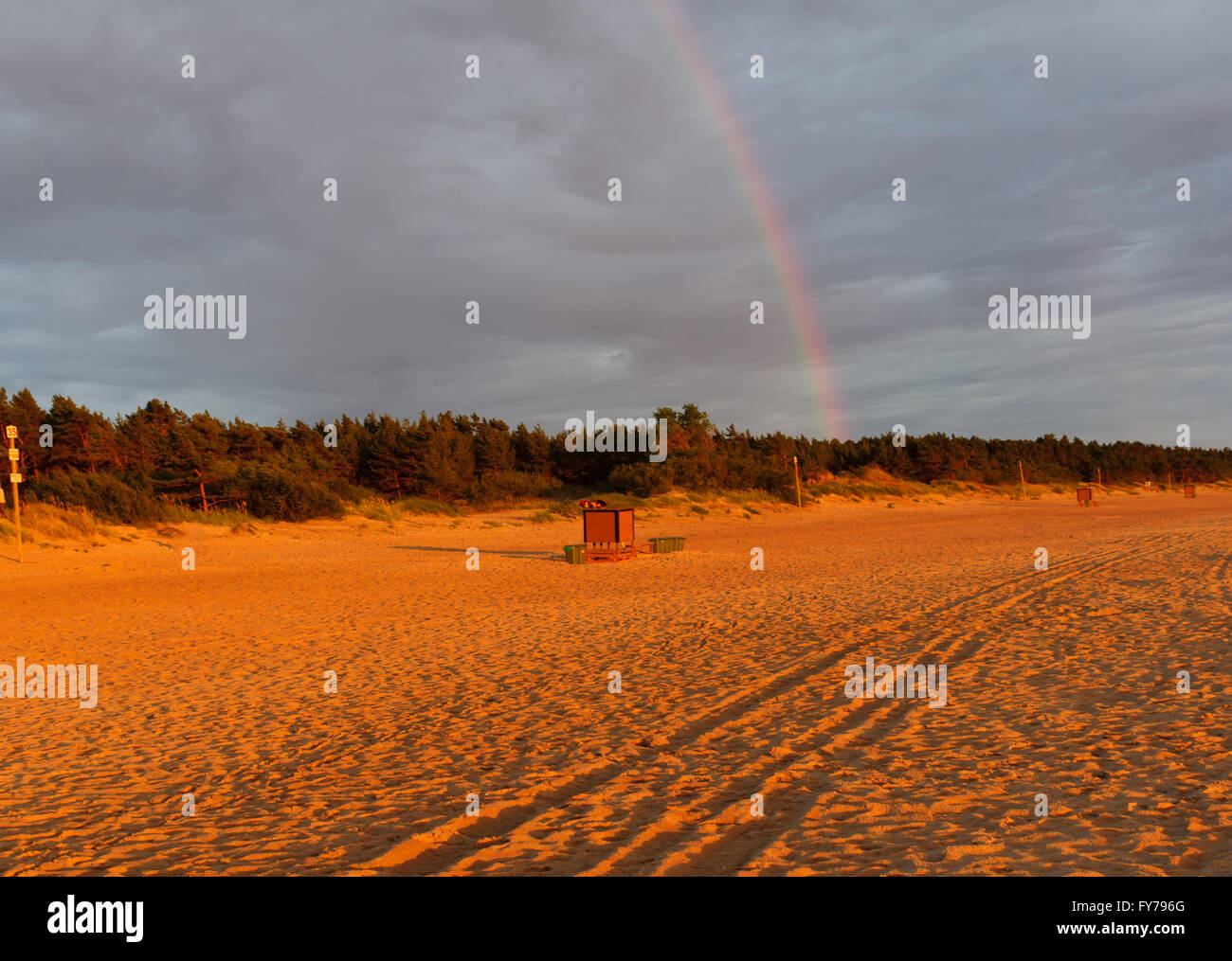 rainbow over a sea beach during a decline Stock Photo