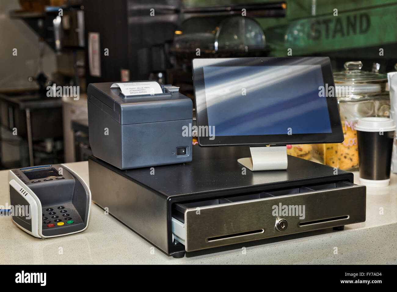 Cashbox, mobile printer, POS terminal and tablet PC on a counter in coffee shop providing innovative and efficient way to serve Stock Photo