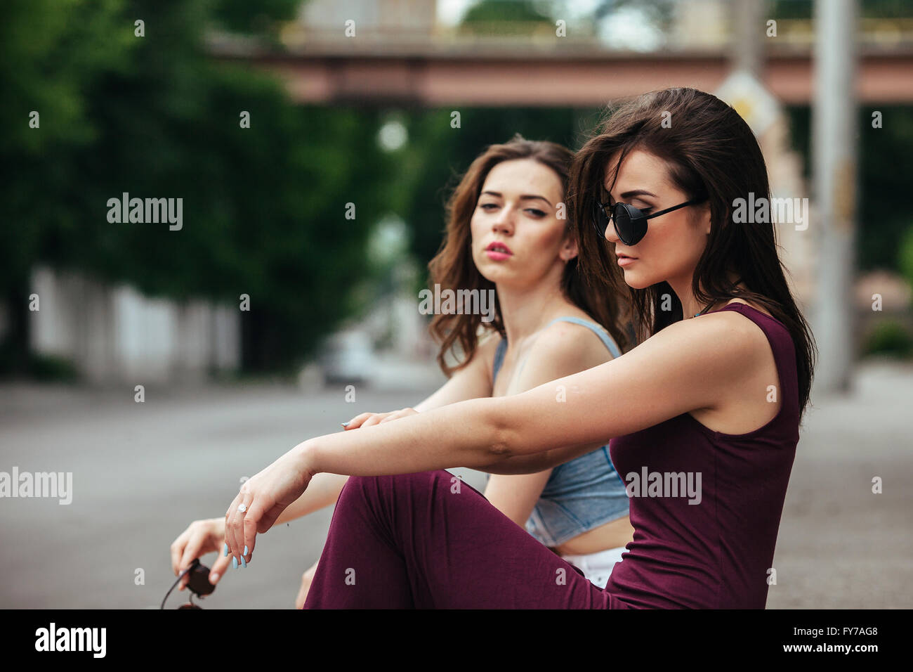 Two beautiful young girls posing on the background of the urban ...