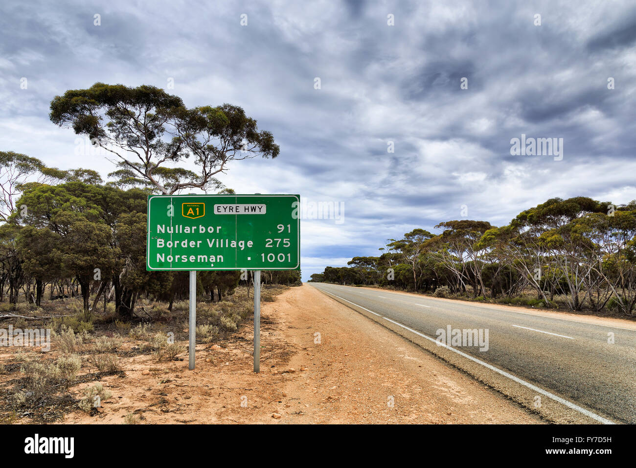 Green information road sign along National Eyre Highway A1 in South Australia somewhere in Nullarbor plain with only a trees Stock Photo