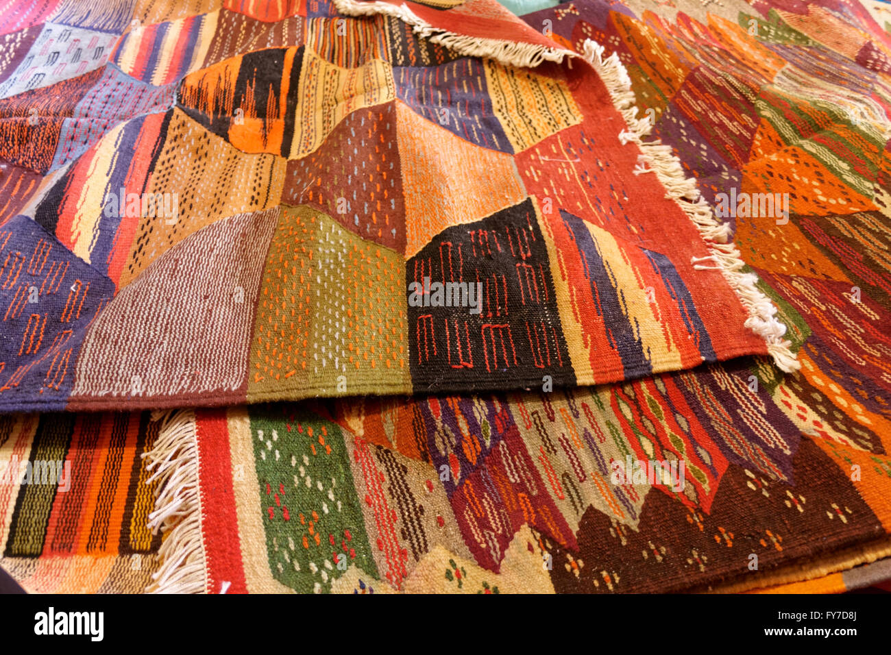 Different Berber carpets laying on the ground in a shop in Morocco. Stock Photo