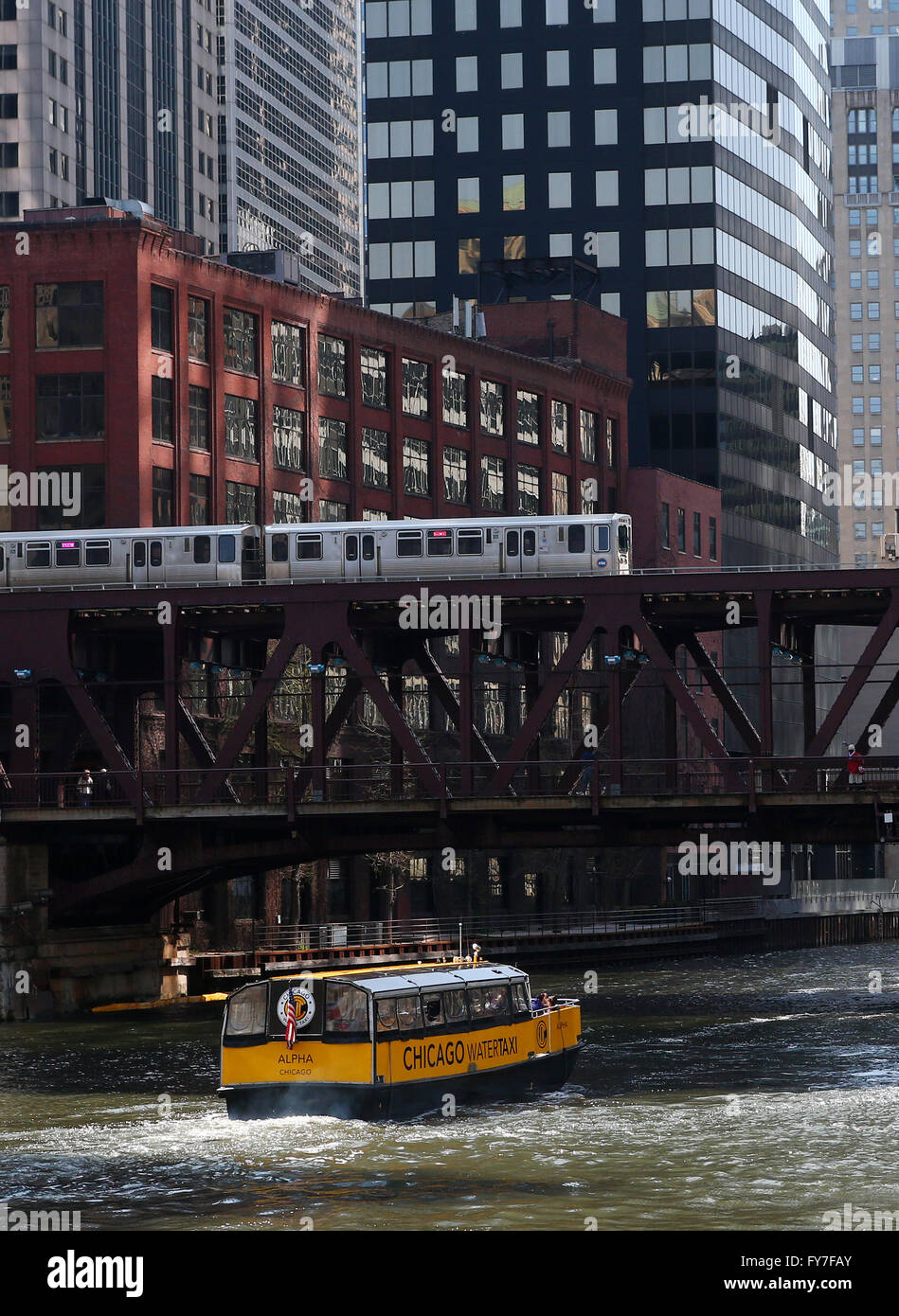 A yellow Chicago water taxi and CTA elevated train cross the Lake Street Bridge along the Chicago River in Chicago, IL, USA Stock Photo