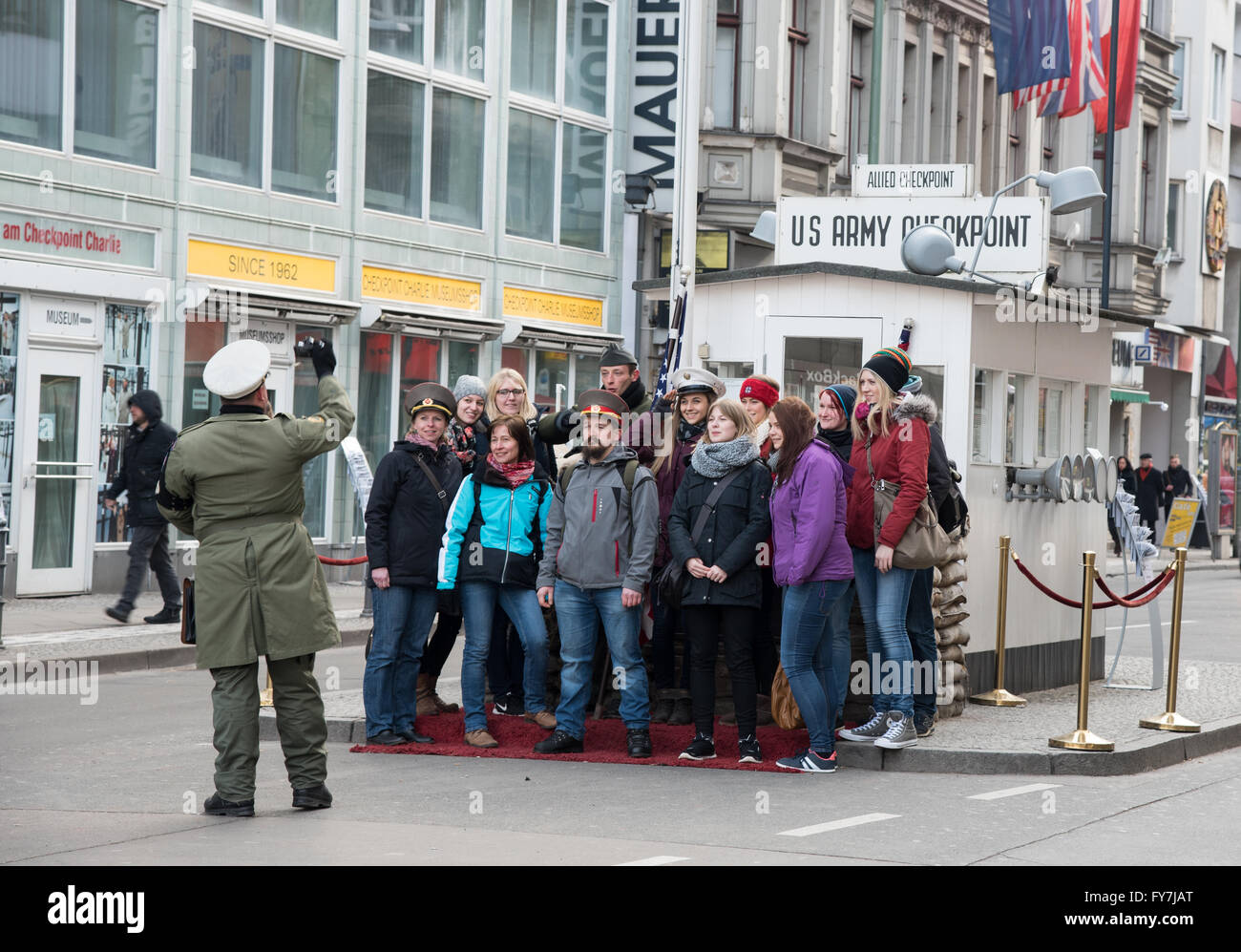 Group of  Tourists taking photos with guards at famous Checkpoint Charlie crossing point bet Stock Photo