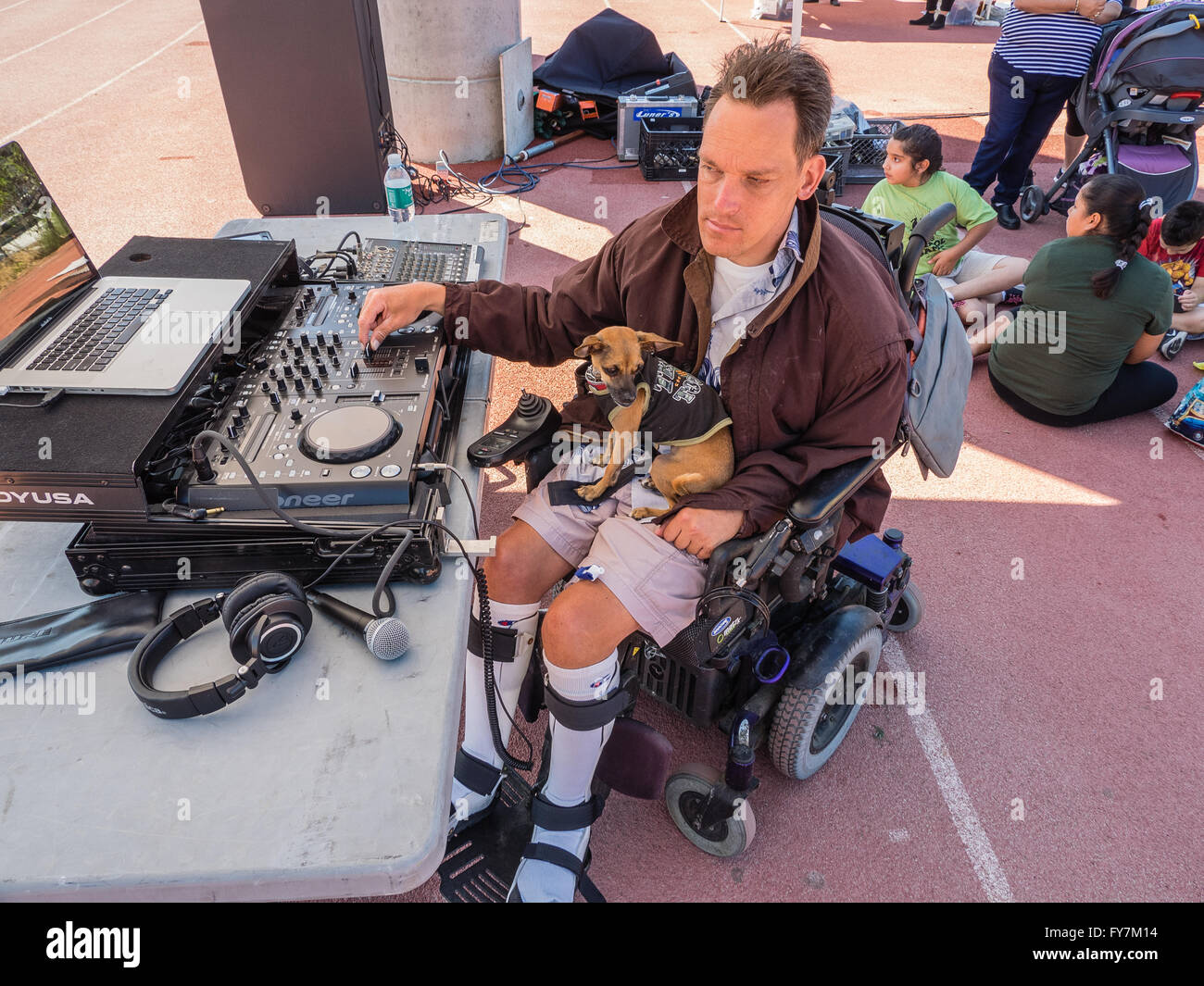 A wheelchair bound disabled middleaged man works his sound equipment as he works as a disc