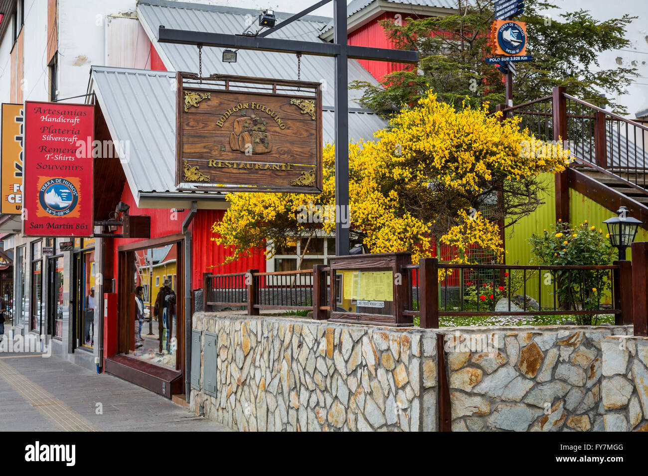 Shops stores and restaurants with broom flowers in downtown Ushuaia, Argentina, South America. Stock Photo