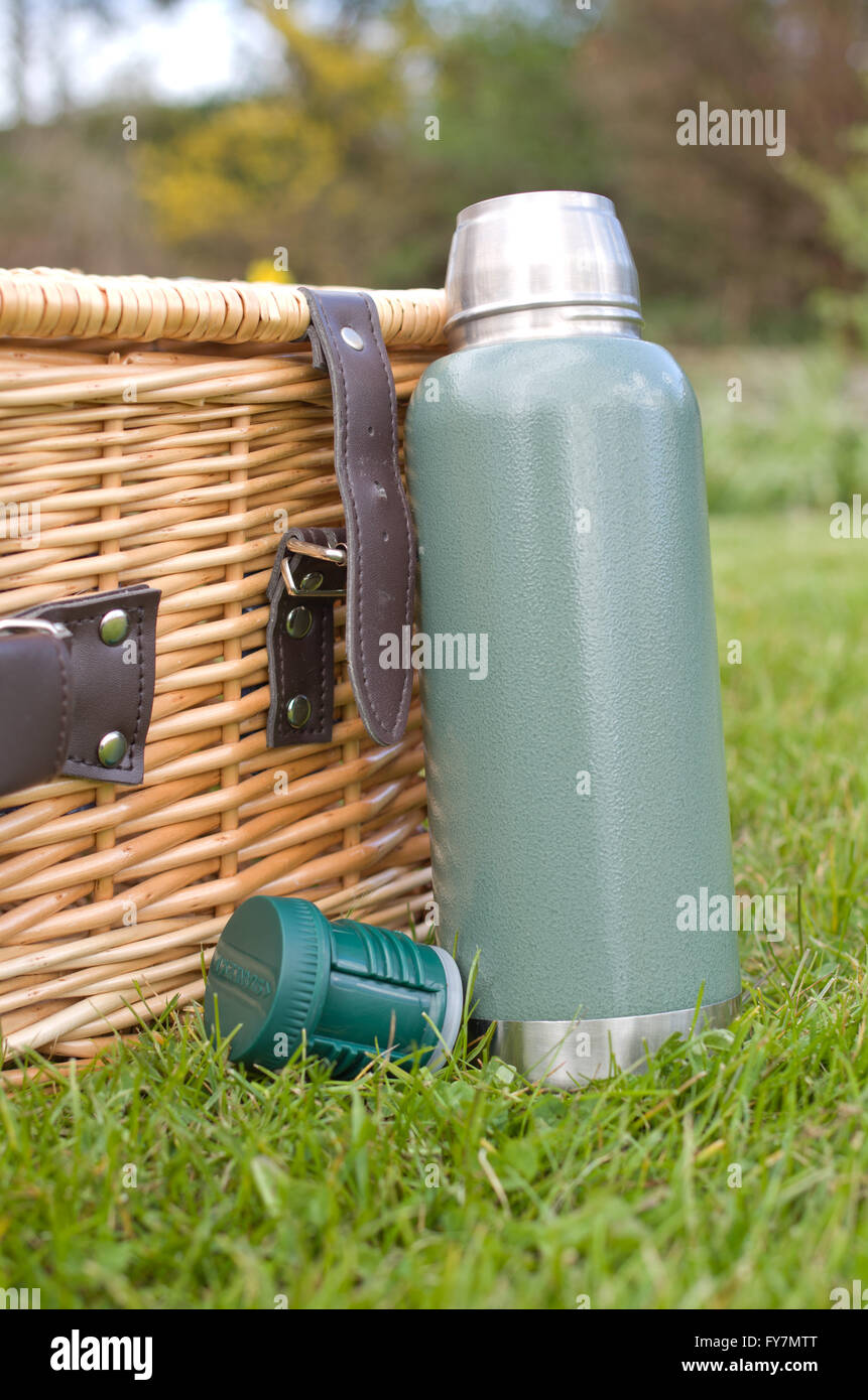 Traditional flask and wicker picnic basket Stock Photo