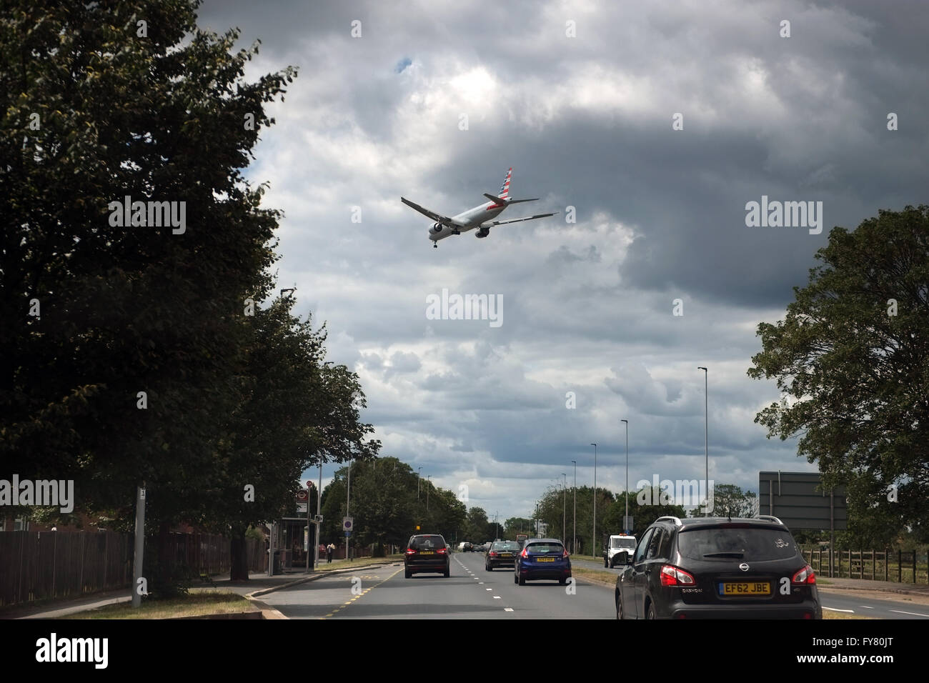 An American Airlines flight on approach to London Heathrow, above the busy A312 (The Parkway)  Road Stock Photo