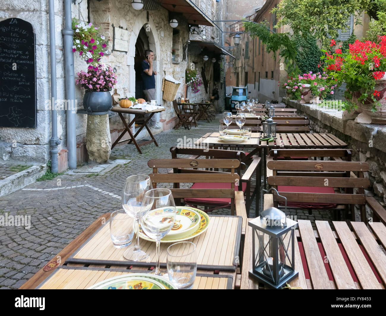 Narrow street and tables at outdoor restaurant in Fiuggi Citta, Lazio, Central Italy Stock Photo