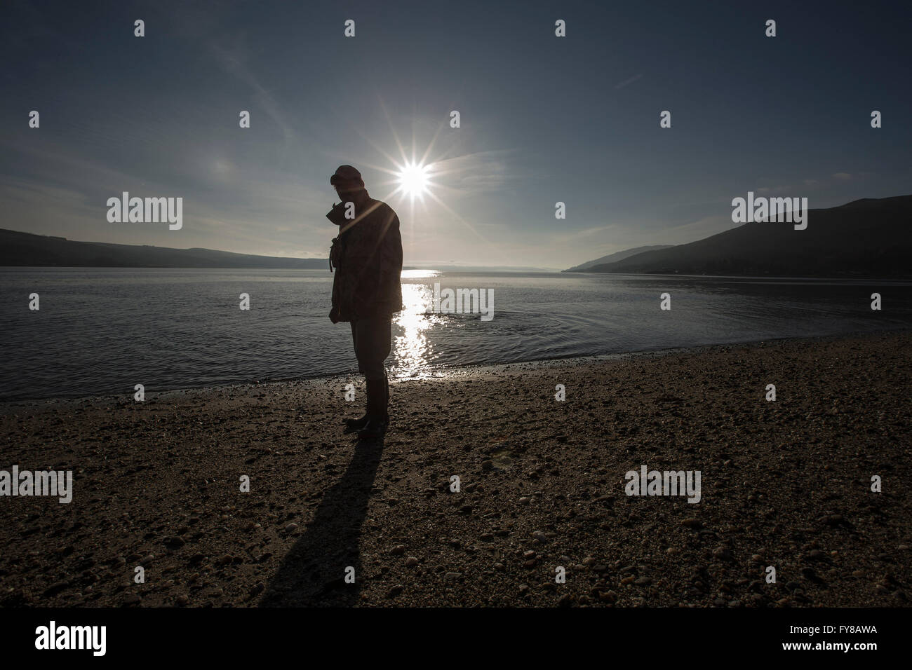 Man in silhouette on beach at Ardentinny Scotland Stock Photo