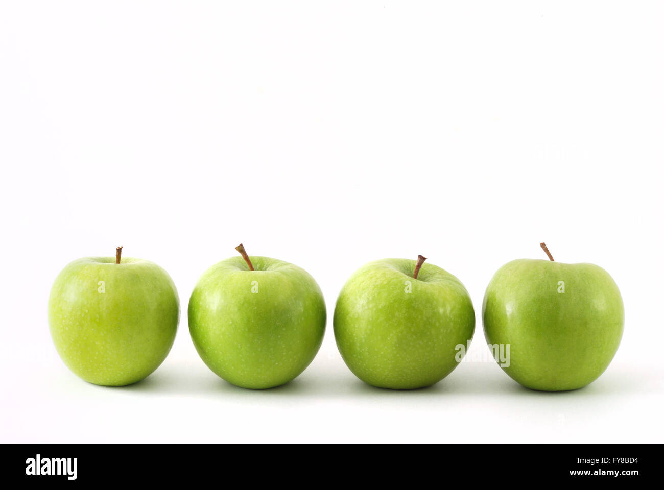 Four green apples in a row Stock Photo - Alamy
