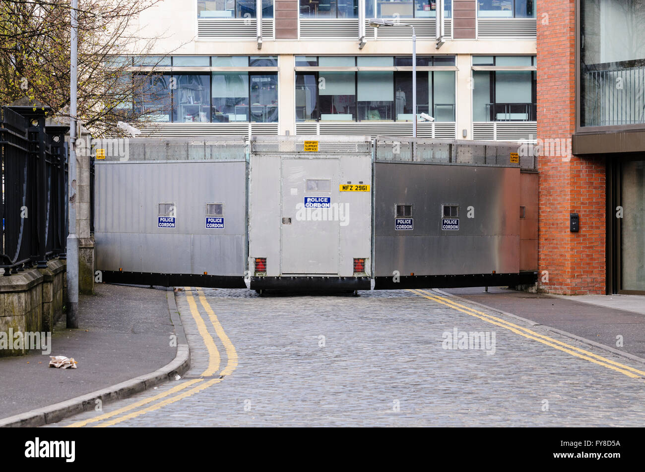 A metal mobile Police Cordon barrier blocks off a street in Belfast