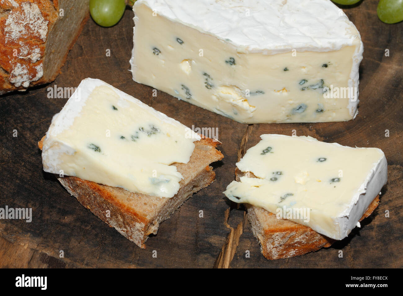 Blue cheese, bread, grapes on a rustic kitchen board Stock Photo Alamy