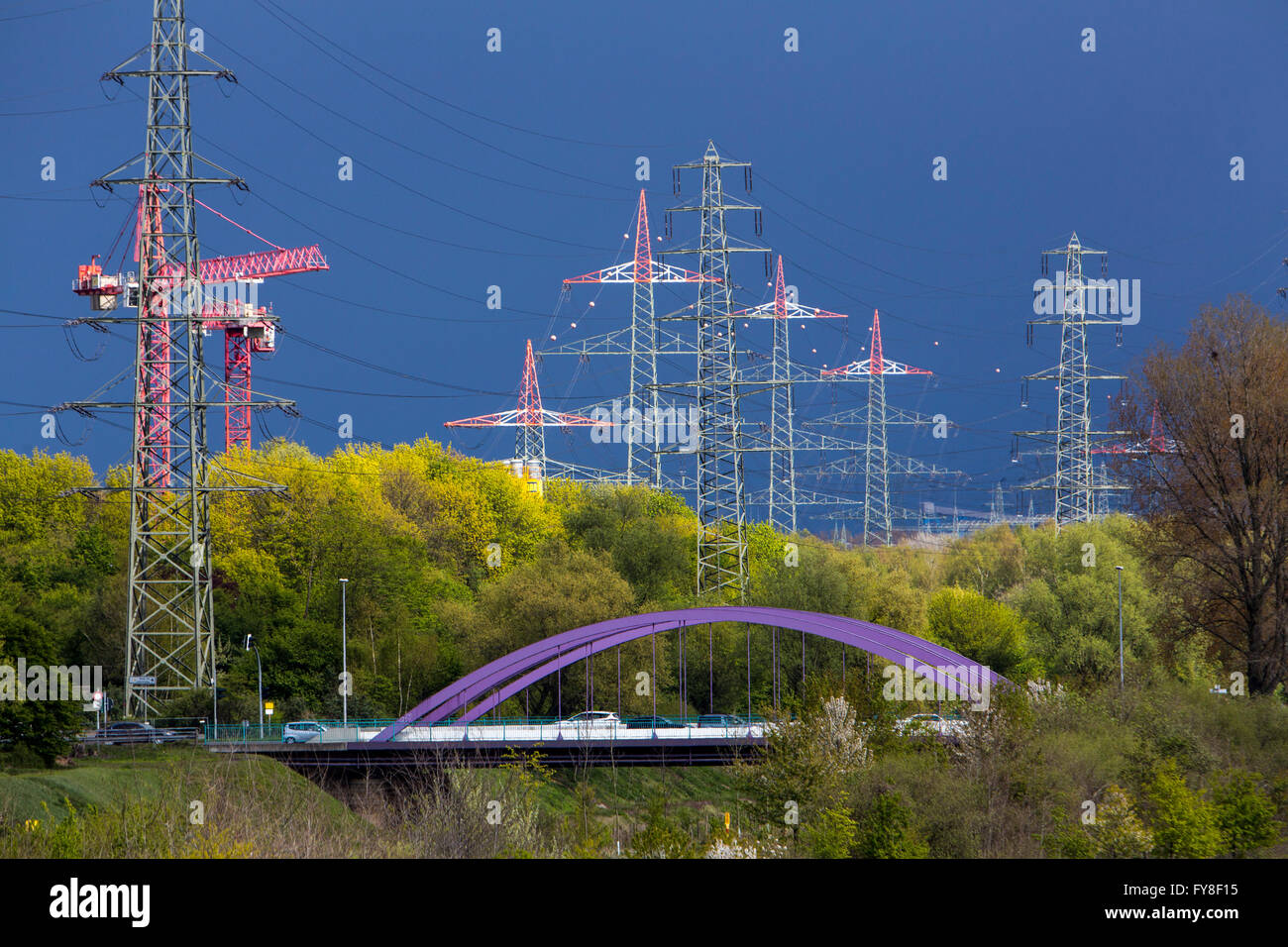 Bridge over river Emscher, in Oberhausen, Germany, dark cloudy sky, high wire electrical power lines, Stock Photo
