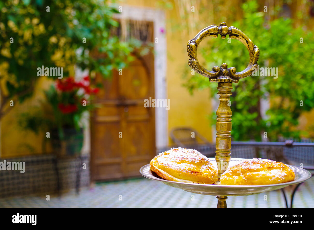Two pastries on an oriental serving tray in a Moroccan interior setting Stock Photo