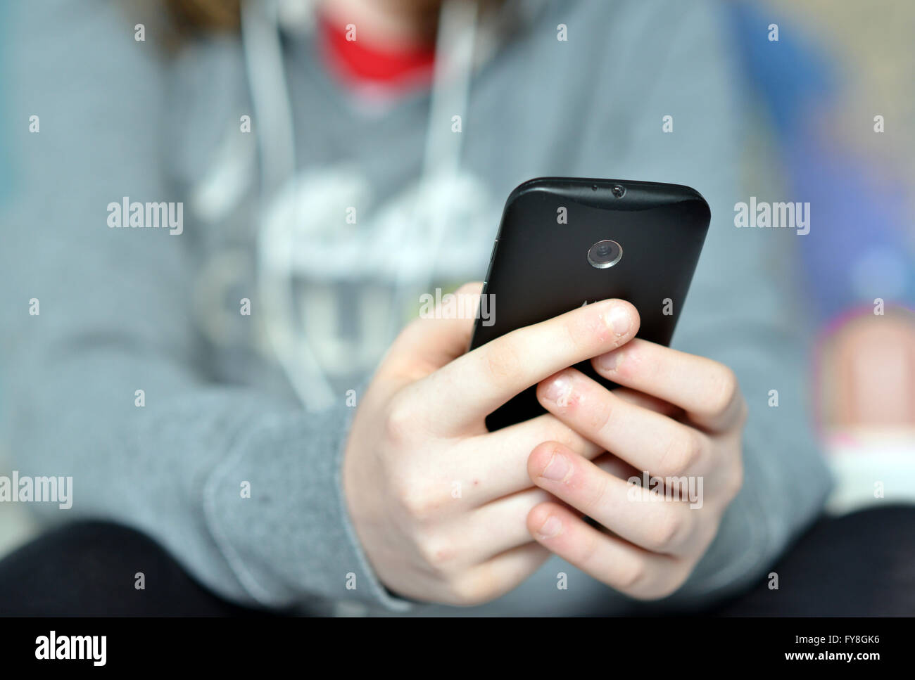 Teen holding mobile (cell) phone in hands Stock Photo