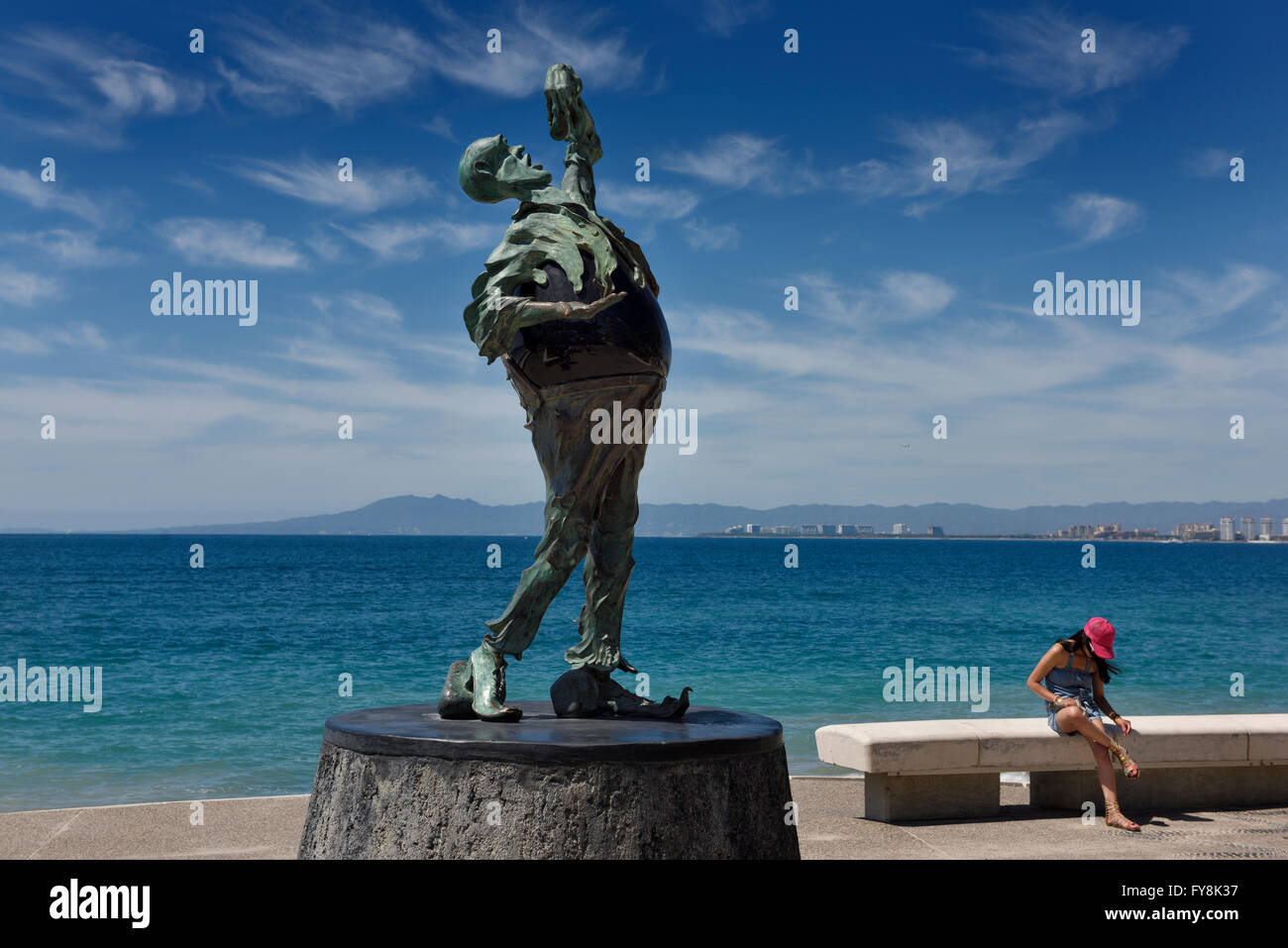 The Subtle Stone Eater sculpture with a tourist on the Malecon Puerto Vallarta Stock Photo