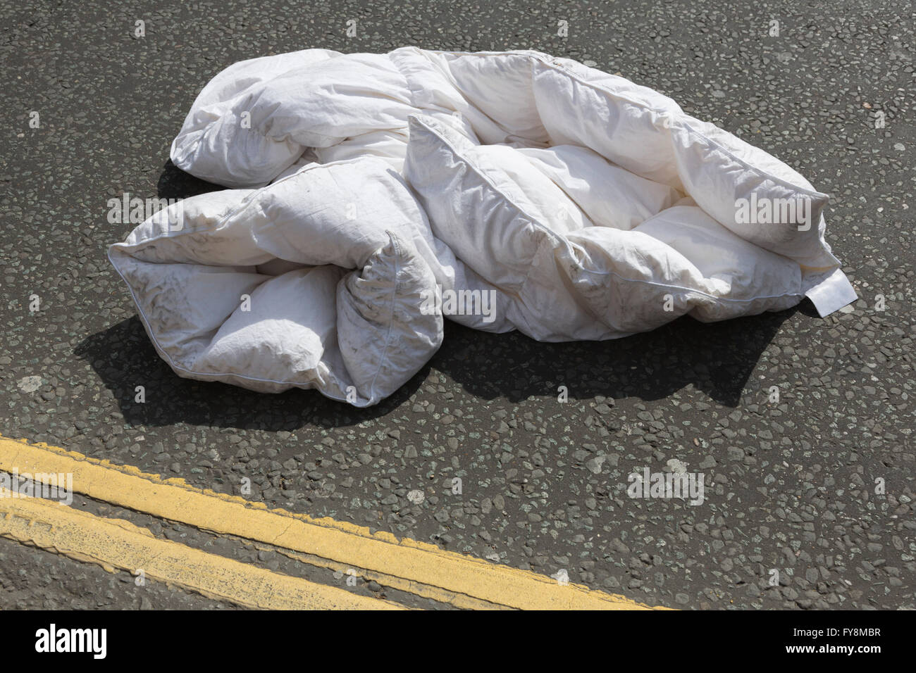 Duvet lying in a street, symbolic image for homelessness, sleeping rough, having no home, living in the street, London, UK Stock Photo