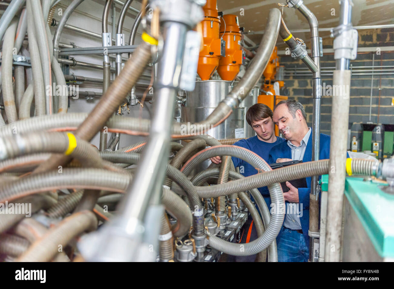 Manager and worker having work meeting in plastics factory Stock Photo