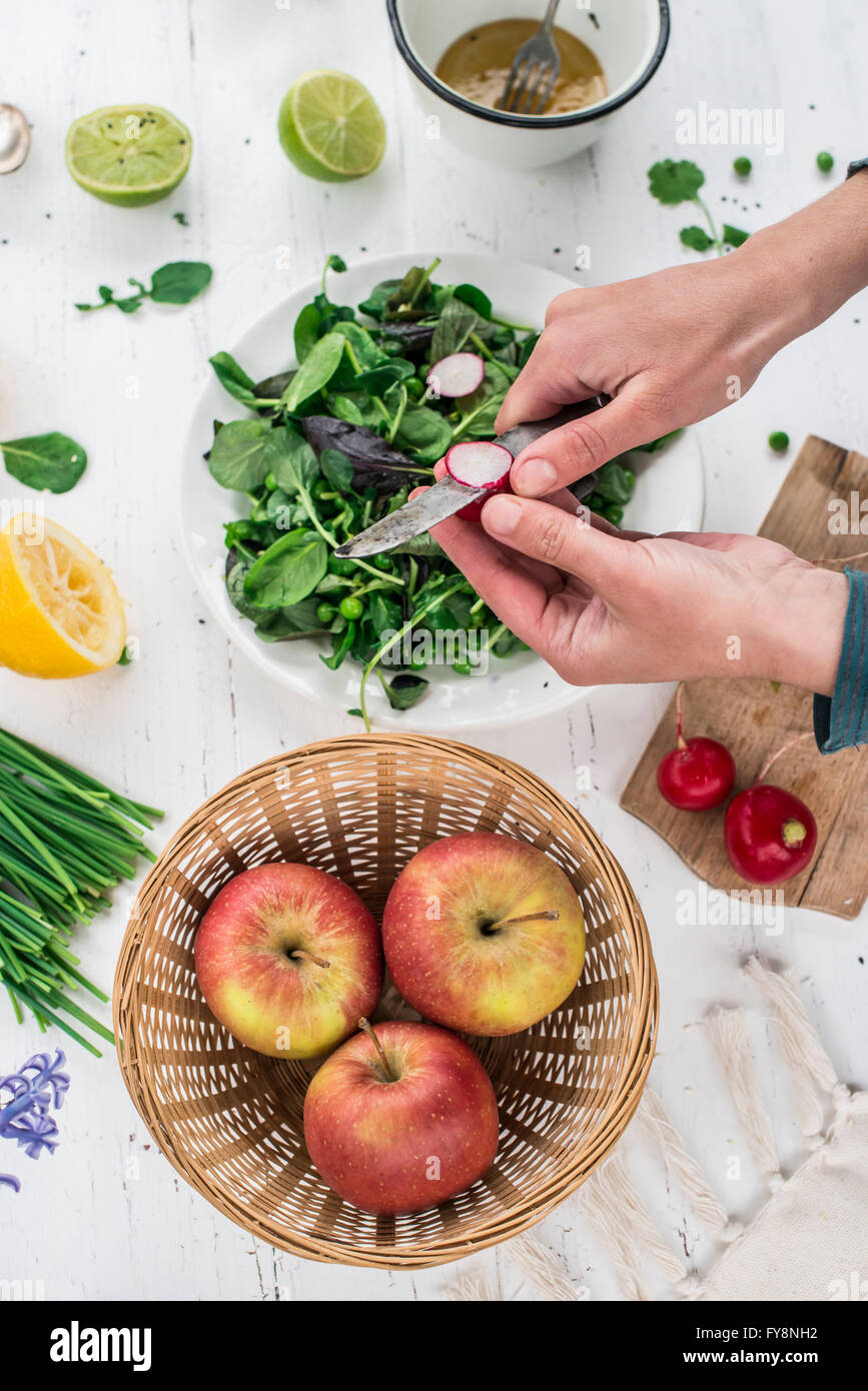 Hand preparing salad cutting red radish Stock Photo Alamy
