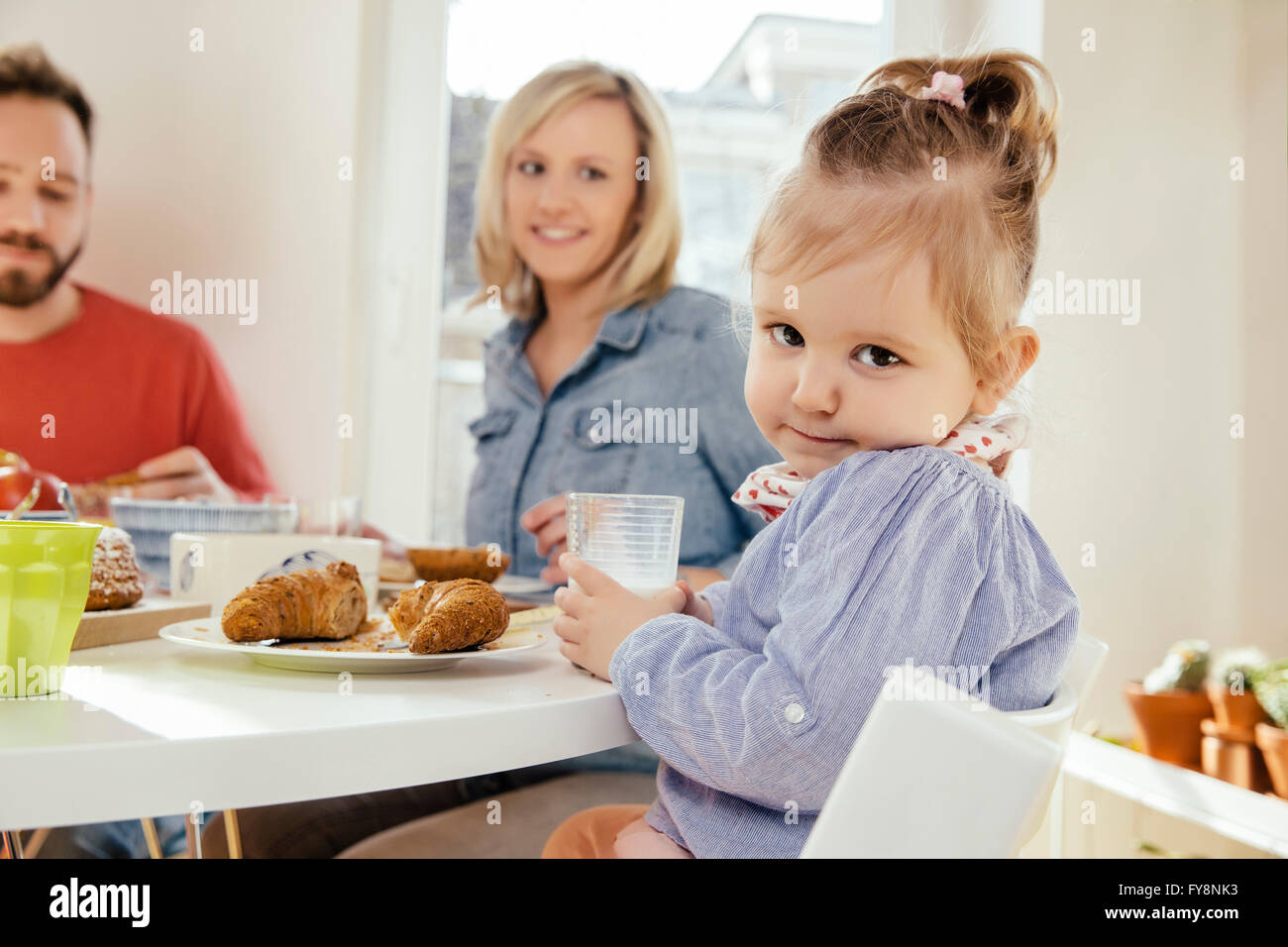 Portrait of little girl with glass of milk at breakfast table Stock Photo