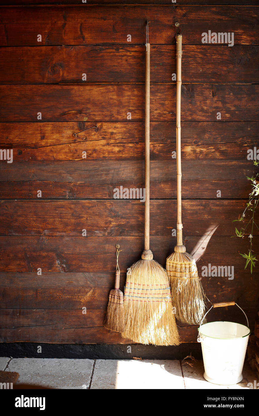 Three brooms hanging on wooden wall Stock Photo Alamy