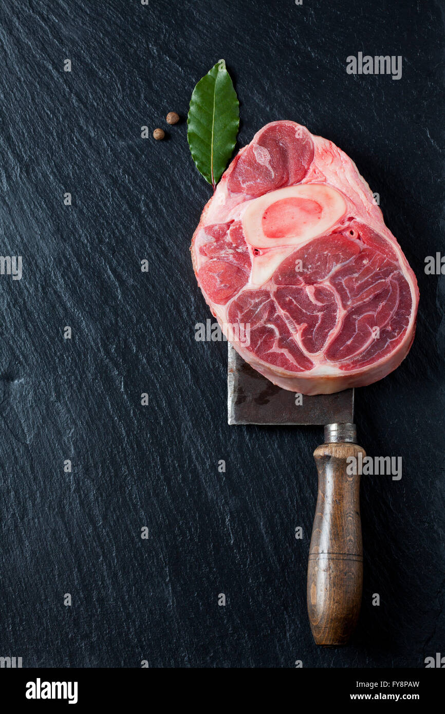 Raw beef shank with bay leaves and allspice on cleaver Stock Photo