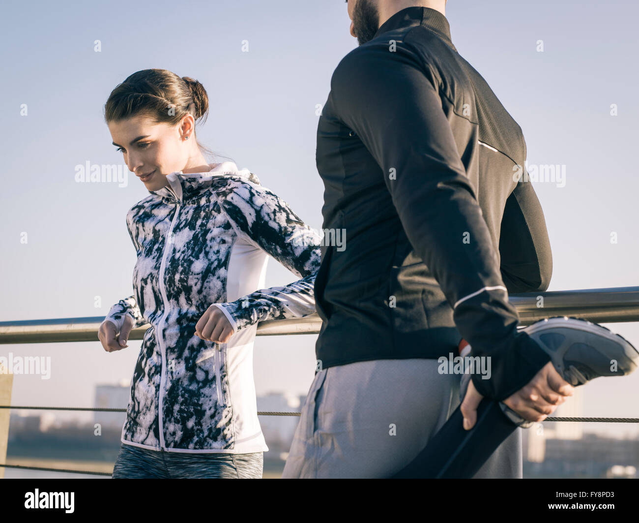 Germany, Cologne, Young couple worming up for workout Stock Photo