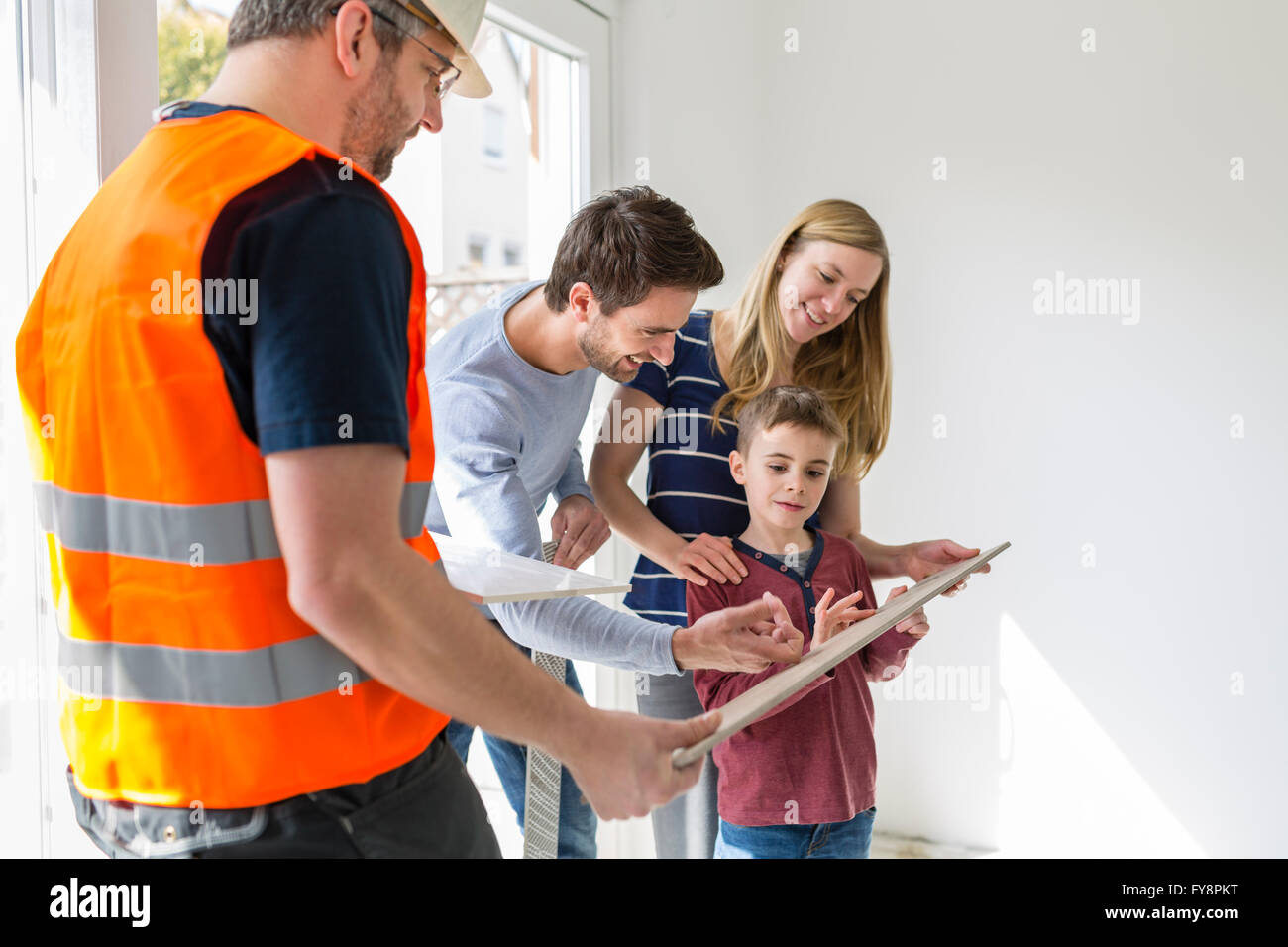 Construction worker showing family tile samples Stock Photo - Alamy