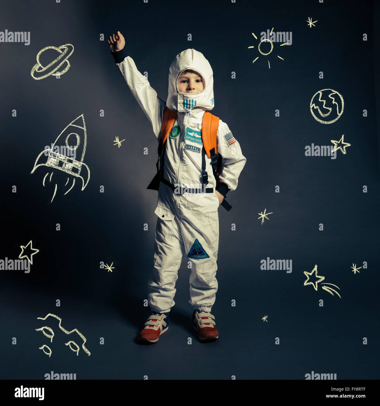 Child with spacesuit orbited by celestial bodies and luminaries Stock Photo