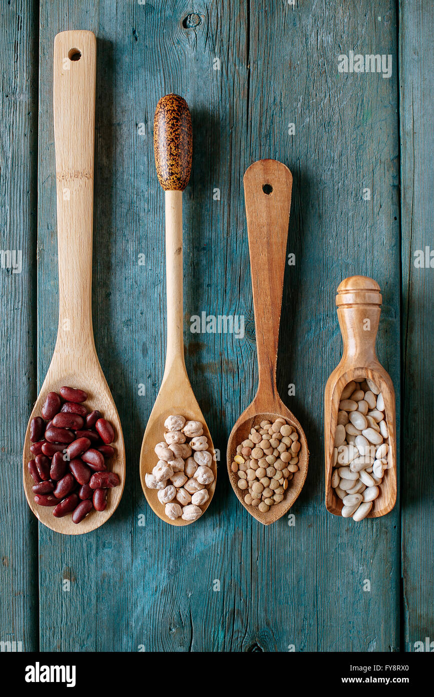 Row of four different wooden spoons with various pulses Stock Photo
