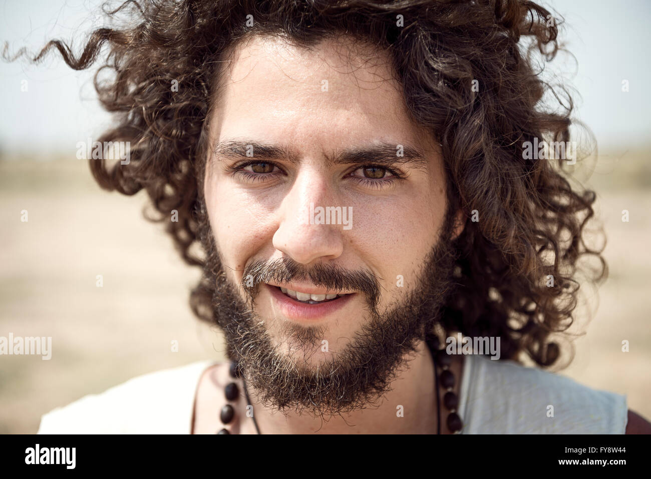 Portrait of man with beard and curly hair Stock Photo - Alamy