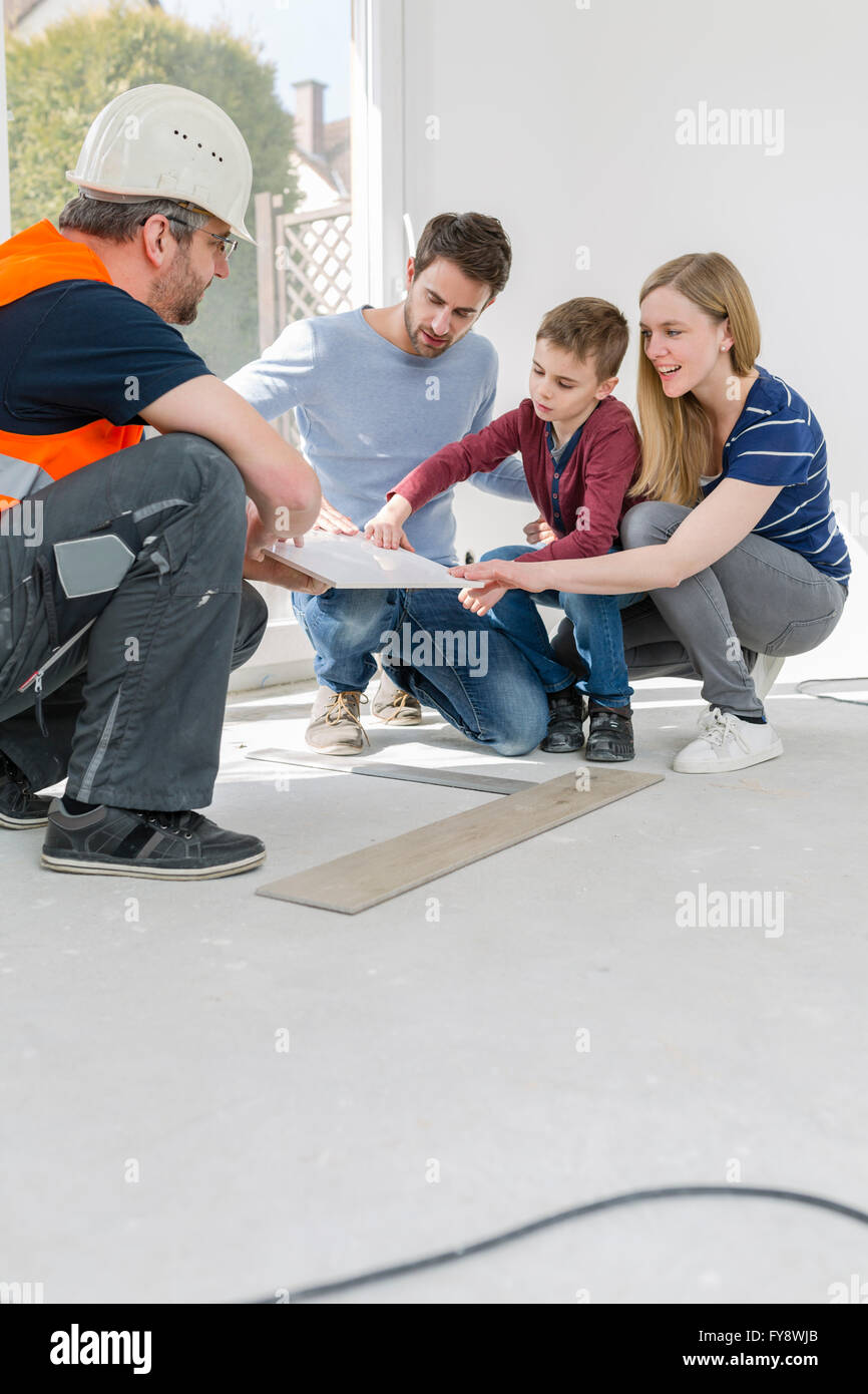 Construction worker showing family tile samples Stock Photo - Alamy