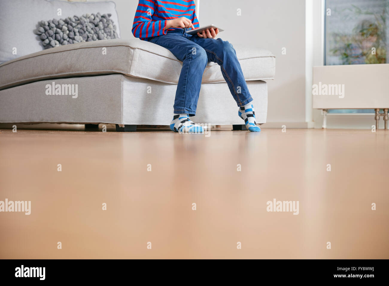 Low section of boy using digital tablet at home Stock Photo