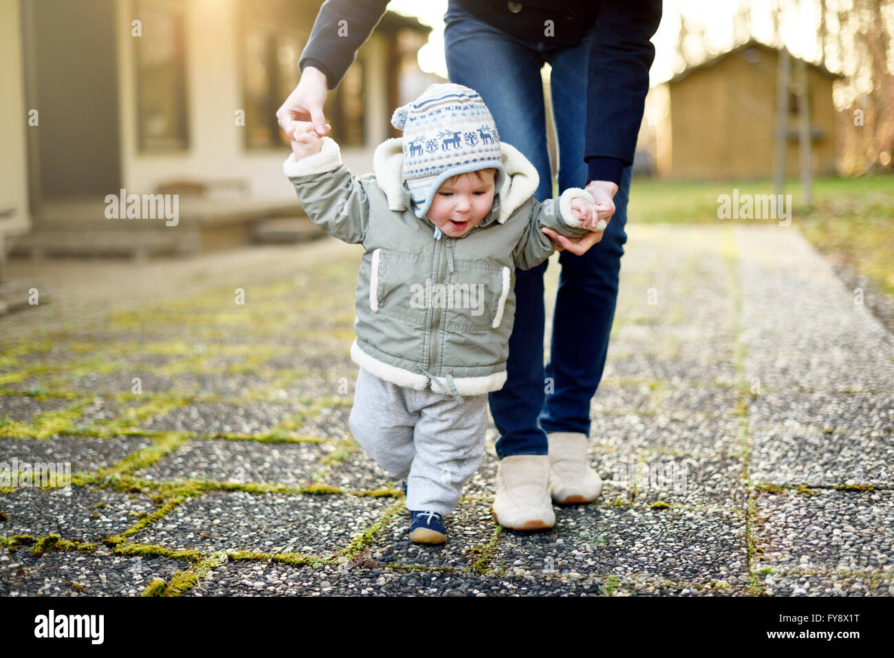 Mother helping baby to walk hi-res stock photography and images - Alamy