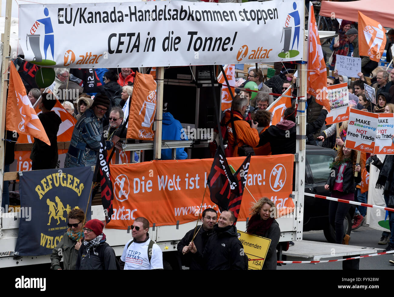 Activisits carry flags and banners, one of which reads 'Stop the EU-Canada trade agreement, CETA is trash' Farmers in tractors which are decorated with banners, one of which reads 'Farmers need an intact climate worldwide', take part in a rally against the controversial transatlantic trade agreement TTIP in Hanover, Germany, 23 April 2016. Organisations for environment and consumer protection as well as for third world relief fear sinking ecological and social standards in Europe and that the agreement gives more power to big corportations. US-President Obama visits the Hanover Messe fair from Stock Photo