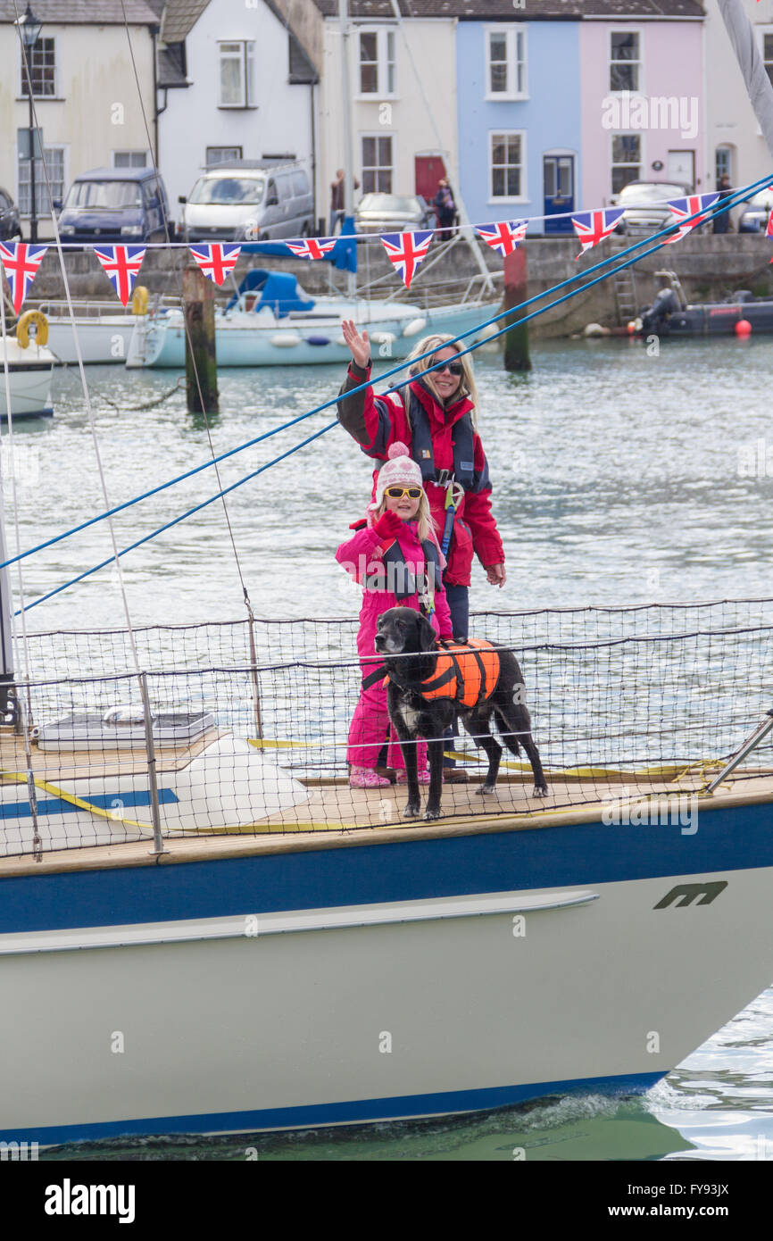 Weymouth, England. 23 April 2016. Queen's 90th Birthday Floating Tribute. Woman, child and dog on sailing boat. People waving. Credit:  Frances Underwood/Alamy Live News Stock Photo