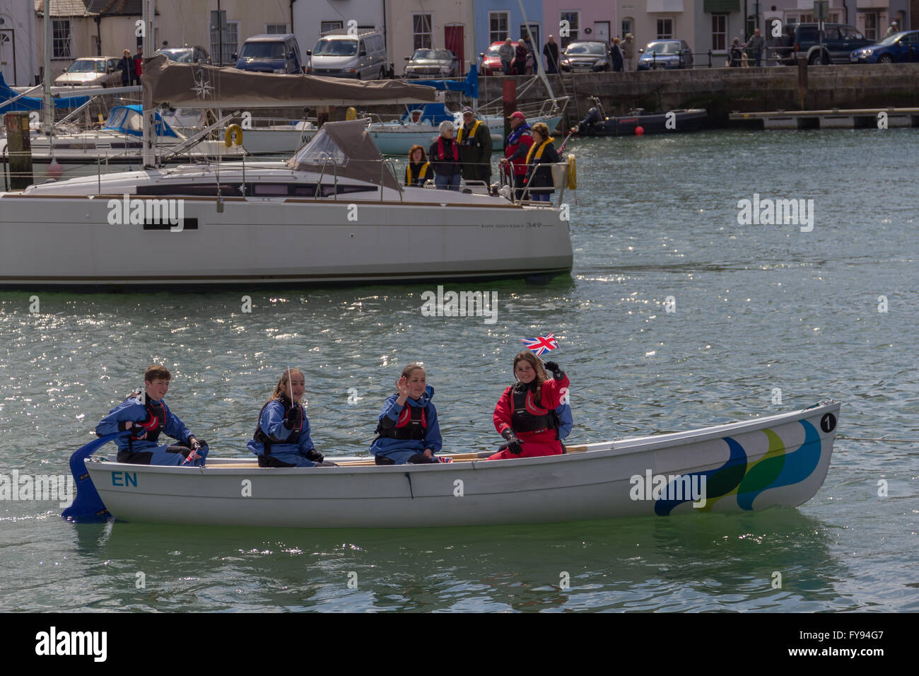 Weymouth, England. 23 April 2016. Queen's 90th Birthday Floating Tribute. Young people in small boat, waving 2. Credit:  Frances Underwood/Alamy Live News Stock Photo