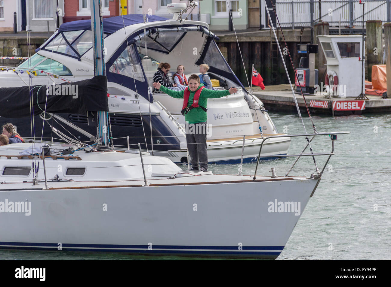 Weymouth, England. 23 April 2016. Queen's 90th Birthday Floating Tribute. Boy in green on boat. Credit:  Frances Underwood/Alamy Live News Stock Photo
