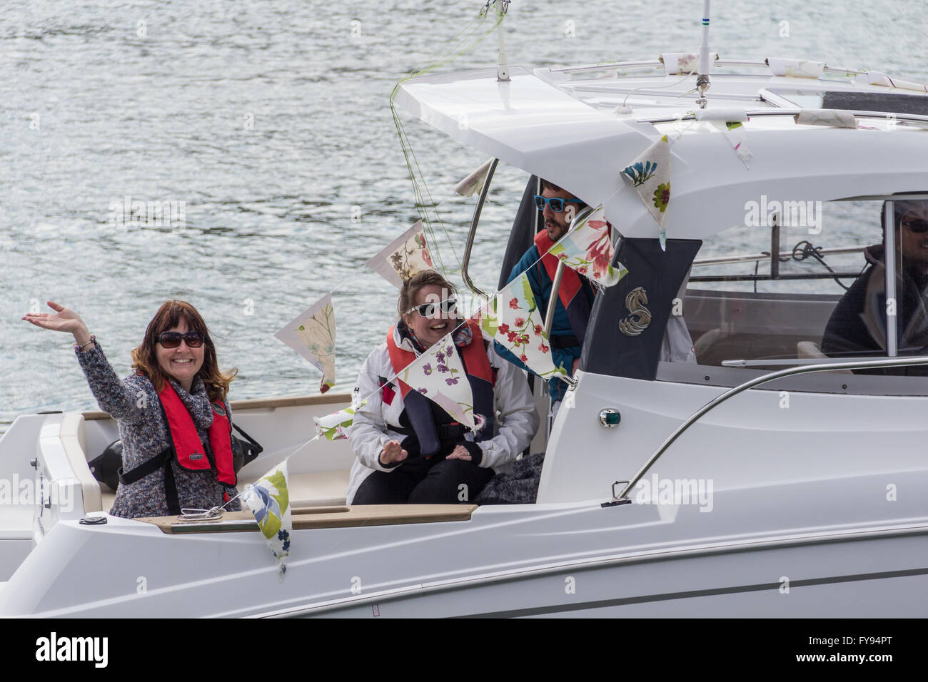 Weymouth, England. 23 April 2016. Queen's 90th Birthday Floating Tribute. Two ladies in boat, smiling and waving. Credit:  Frances Underwood/Alamy Live News Stock Photo