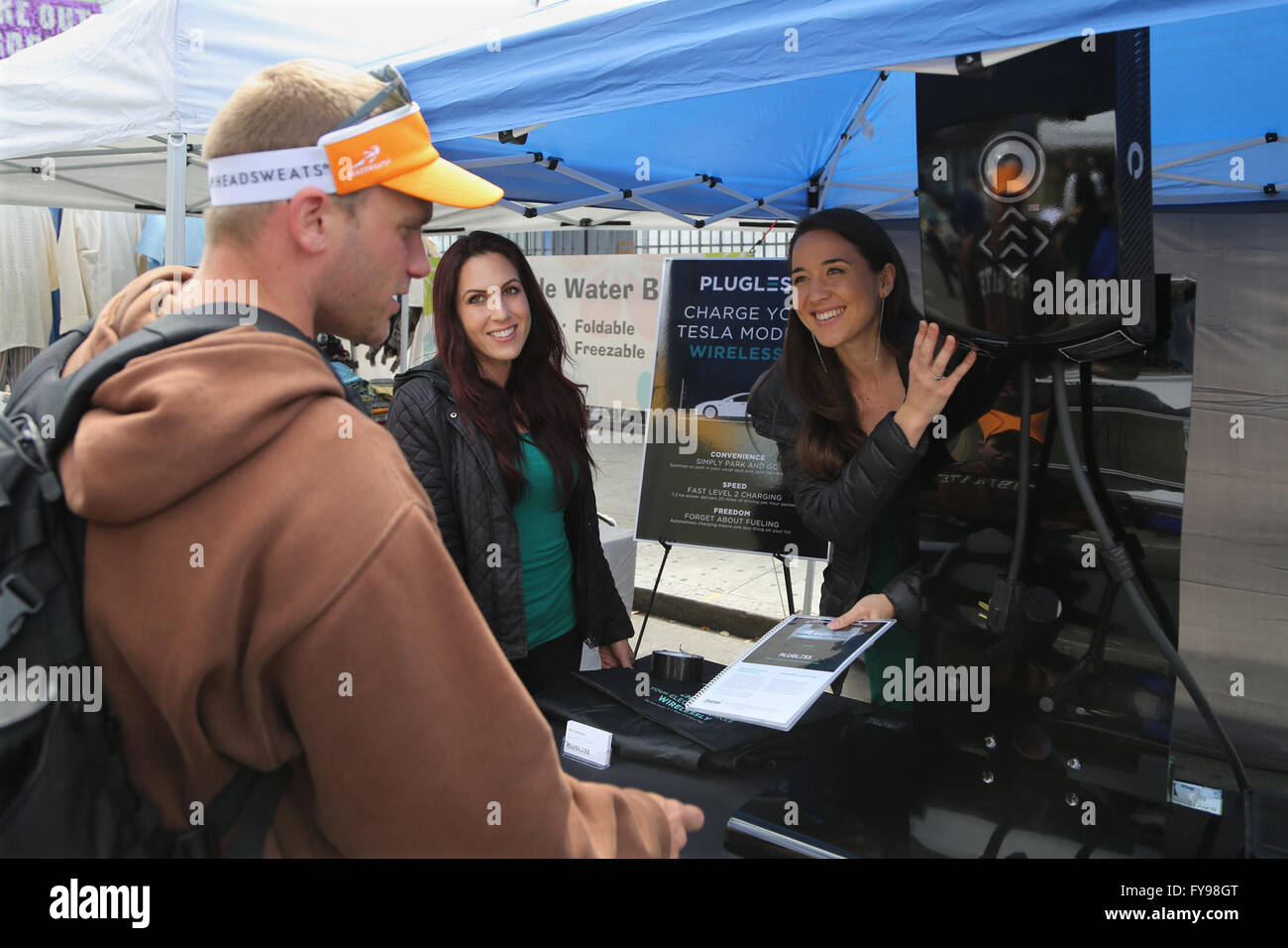 San Francisco, USA. 23rd Apr, 2016. An Earth Day event worker (R) educates an visitor about charging systems for electric vehicles in downtown San Francisco, the United States, on April 23, 2016. The annual Earth Day San Francisco Street Fest was held in San Francisco on Saturday. Environmental activists brought the public an educational and entertaining green event to help raise their ecological awareness. © Liu Yilin/Xinhua/Alamy Live News Stock Photo