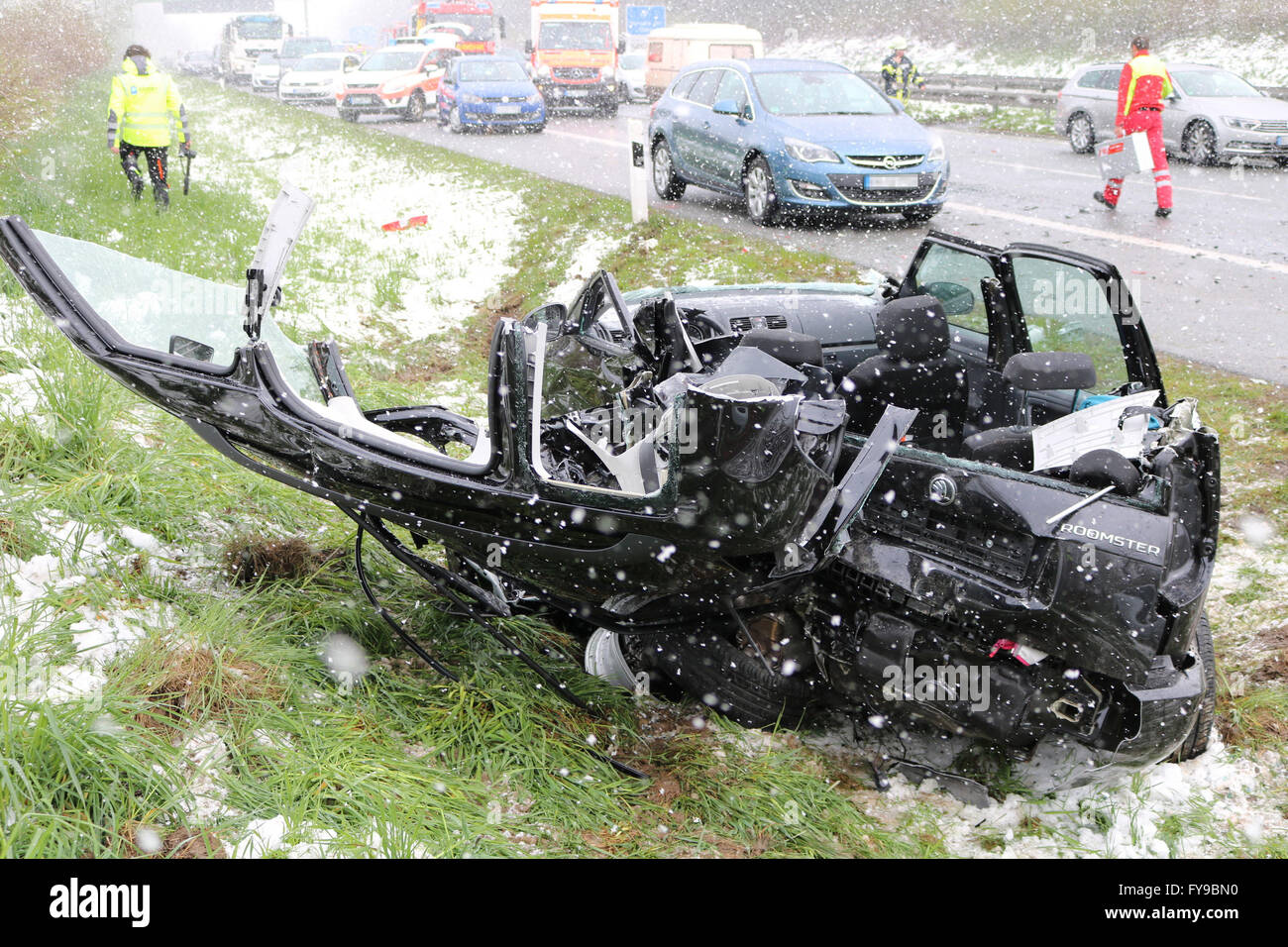 A7 motorway near Betzigau, Germany. 24th April, 2016. Emergency and rescue services are at work behind a crashed car on the A7 motorway near Betzigau, germany, 24 April 2016. Several passengers were injured and cars damaged during a mass crash on the motorway due to the ice and snow slippery surface. Credit:  dpa picture alliance/Alamy Live News Stock Photo